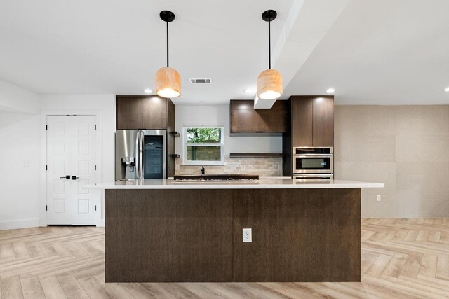 kitchen featuring light countertops, dark brown cabinets, appliances with stainless steel finishes, and recessed lighting