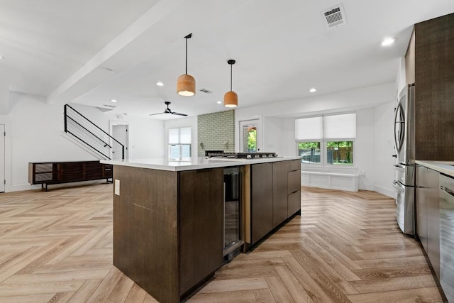 kitchen featuring dark brown cabinets, modern cabinets, light countertops, wine cooler, and a kitchen island