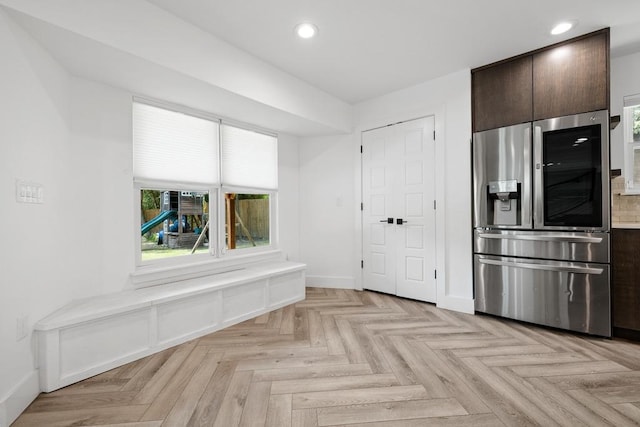 kitchen featuring recessed lighting, dark brown cabinets, plenty of natural light, and stainless steel fridge with ice dispenser