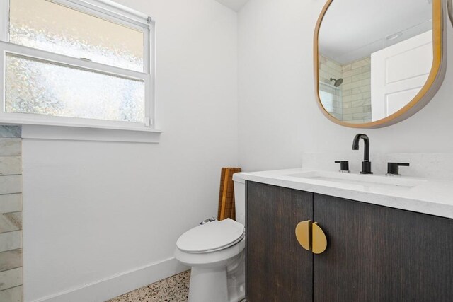 bathroom featuring speckled floor, vanity, toilet, and baseboards