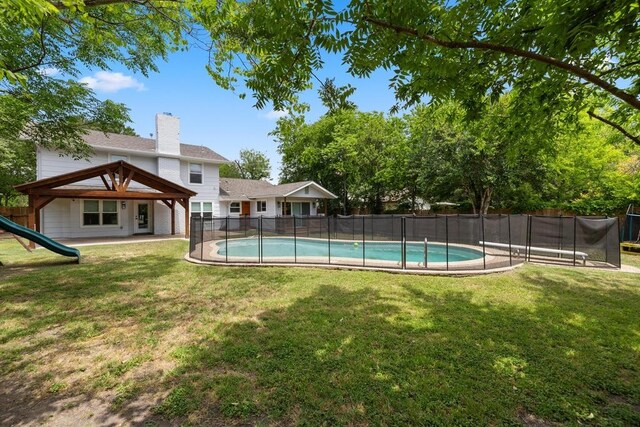 view of swimming pool featuring a fenced in pool, a fenced backyard, a yard, a patio, and a trampoline