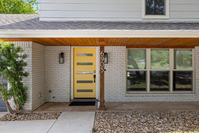view of exterior entry with brick siding