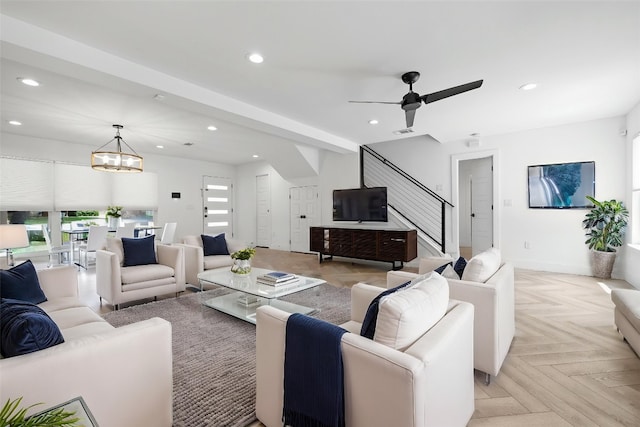 living room with baseboards, recessed lighting, ceiling fan with notable chandelier, and stairway