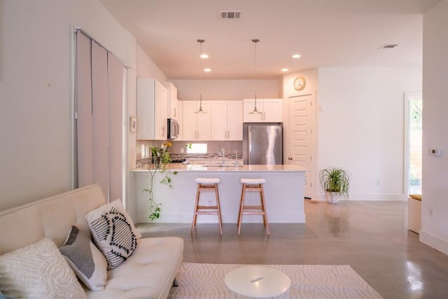 living area with baseboards, concrete flooring, visible vents, and recessed lighting
