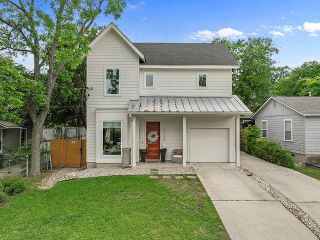 traditional-style house with a front lawn, a standing seam roof, a garage, metal roof, and fence