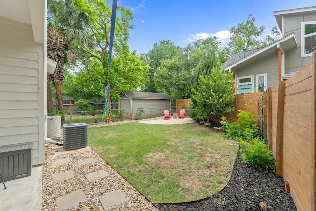 view of yard with a fenced backyard and central AC unit