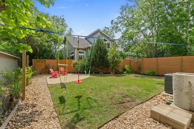 view of yard with central air condition unit, a fenced backyard, and a patio area