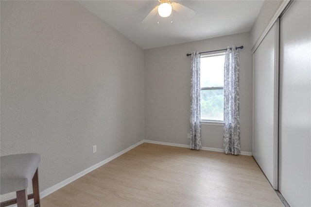 spare room with baseboards, a ceiling fan, and light wood-style floors