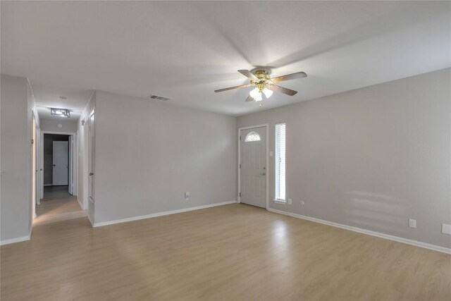 interior space with ceiling fan, baseboards, visible vents, and light wood-style flooring