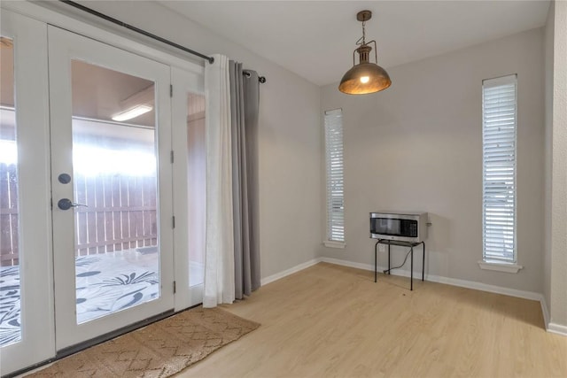 entryway featuring light wood-type flooring, baseboards, and heating unit
