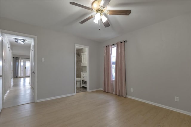 unfurnished room with light wood-style floors, a ceiling fan, and baseboards