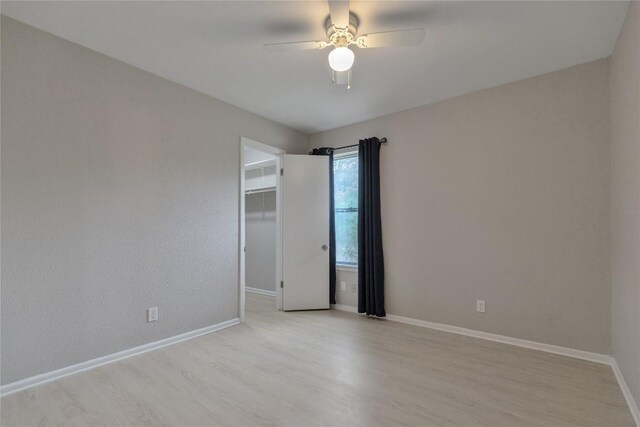 unfurnished room featuring ceiling fan, baseboards, and light wood-style floors