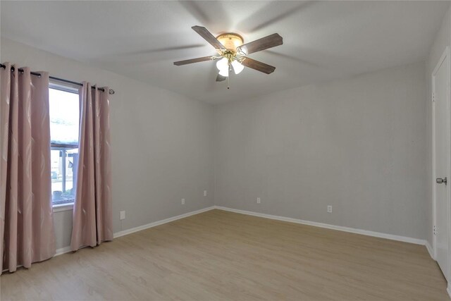 unfurnished room featuring light wood-style floors, a ceiling fan, and baseboards