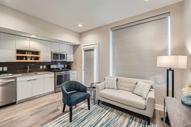 living room with light wood finished floors, baseboards, and recessed lighting
