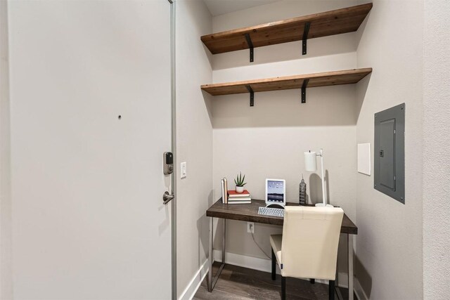home office featuring dark wood-style floors, baseboards, and electric panel