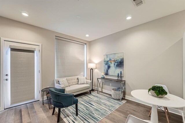 sitting room with baseboards, wood finished floors, visible vents, and recessed lighting