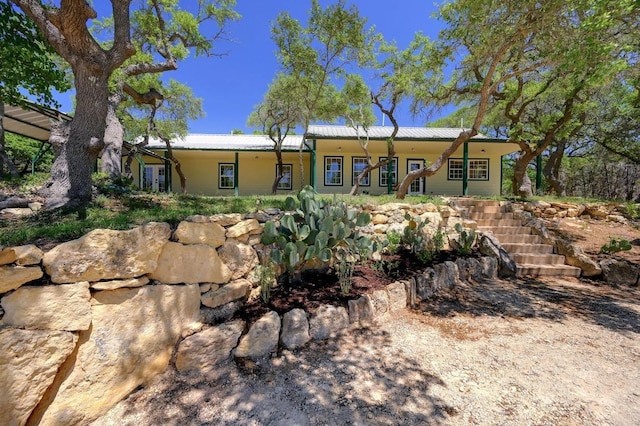 view of front of house with stairs and metal roof