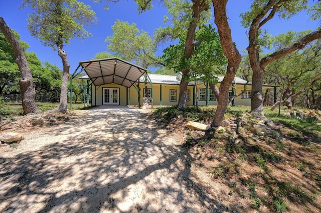 view of front of home with dirt driveway and french doors