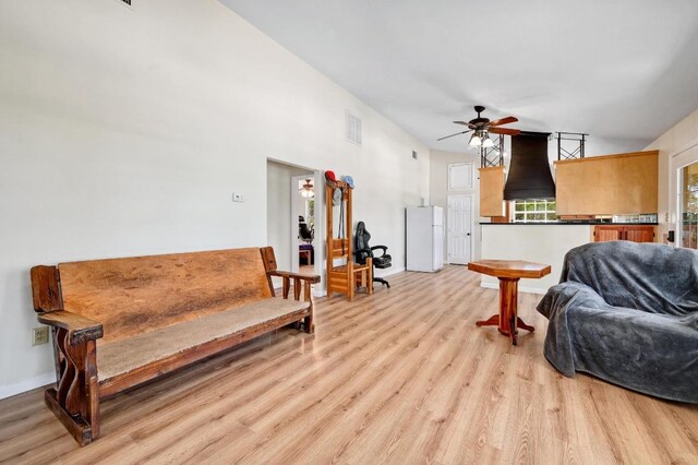 living room with baseboards, a ceiling fan, visible vents, and light wood-style flooring