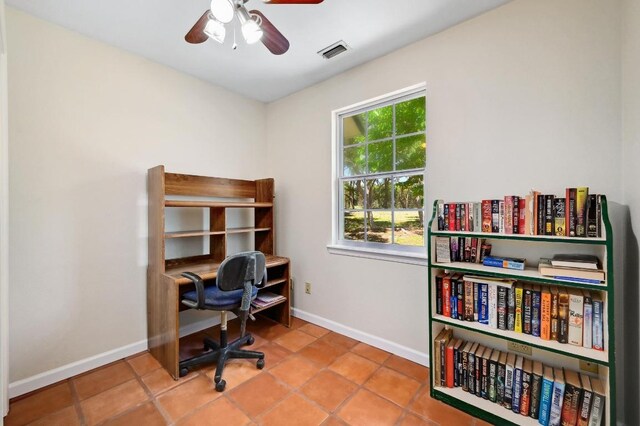 tiled office space featuring visible vents, a ceiling fan, and baseboards