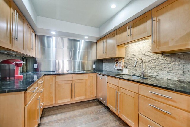 kitchen with stainless steel dishwasher, decorative backsplash, and a sink