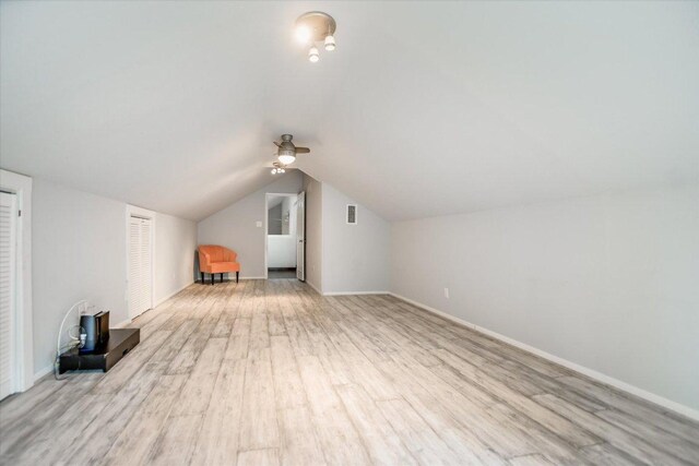 bonus room with vaulted ceiling, a ceiling fan, wood finished floors, baseboards, and visible vents