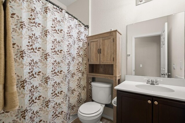 full bath featuring vanity, curtained shower, and toilet