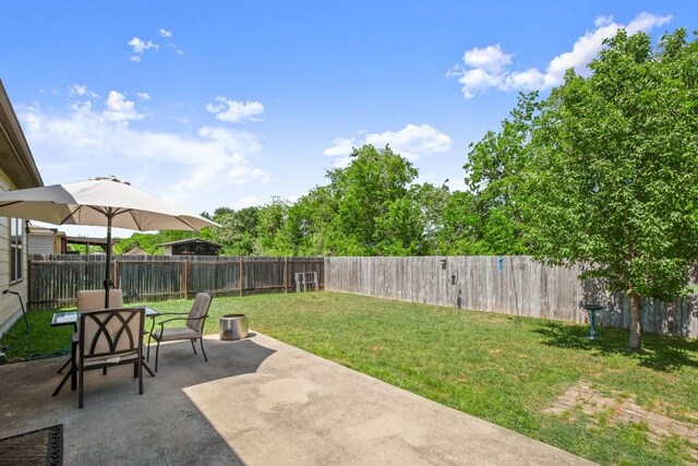 view of yard with a fenced backyard, outdoor dining space, and a patio