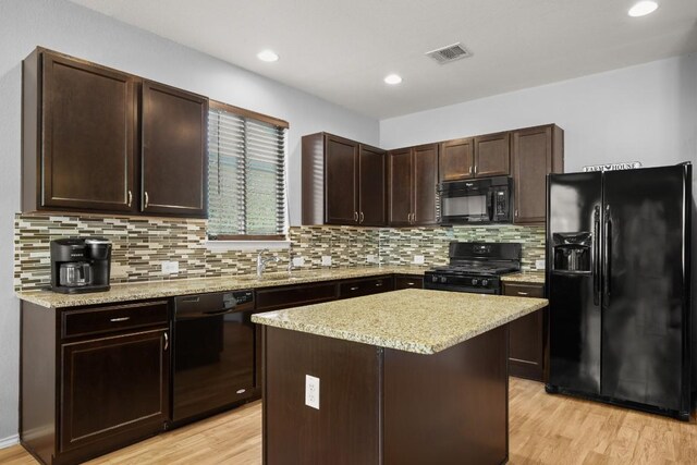 kitchen featuring light wood finished floors, dark brown cabinets, visible vents, decorative backsplash, and black appliances