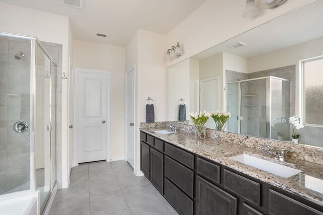 bathroom with tile patterned floors, a sink, double vanity, and a stall shower