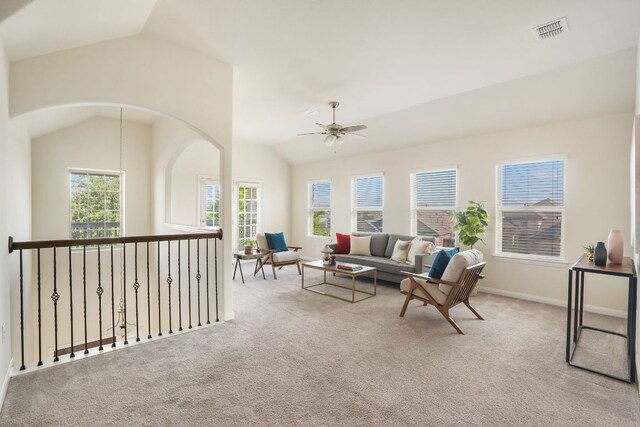 living area with vaulted ceiling, baseboards, visible vents, a ceiling fan, and carpet floors