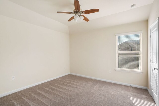 spare room with a ceiling fan, baseboards, and light carpet