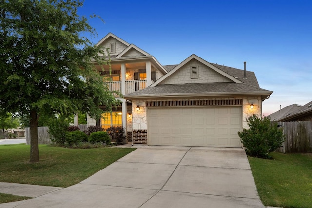 view of front of home featuring a balcony, concrete driveway, fence, a front yard, and a garage