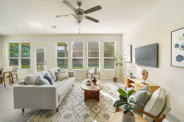 living room with plenty of natural light, baseboards, visible vents, and ceiling fan