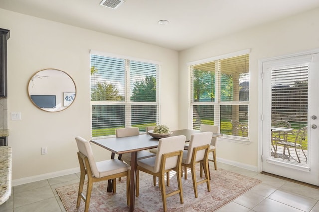 dining space featuring baseboards, visible vents, and light tile patterned floors