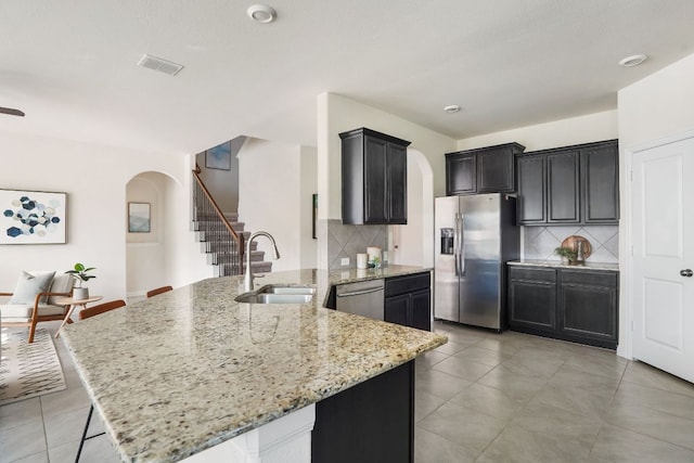 kitchen with arched walkways, visible vents, appliances with stainless steel finishes, and a sink