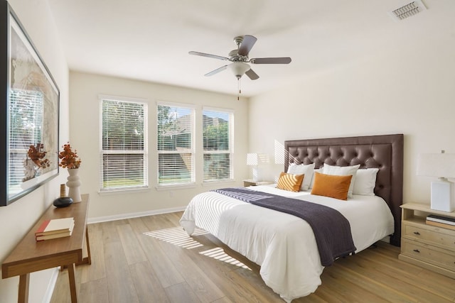 bedroom with ceiling fan, baseboards, visible vents, and light wood-type flooring
