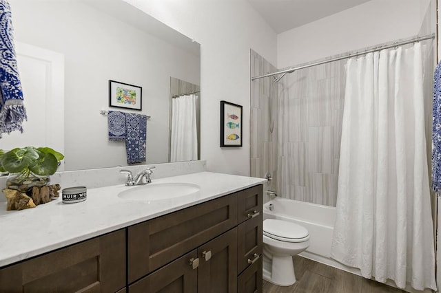 bathroom with shower / bath combination with curtain, wood finished floors, vanity, and toilet