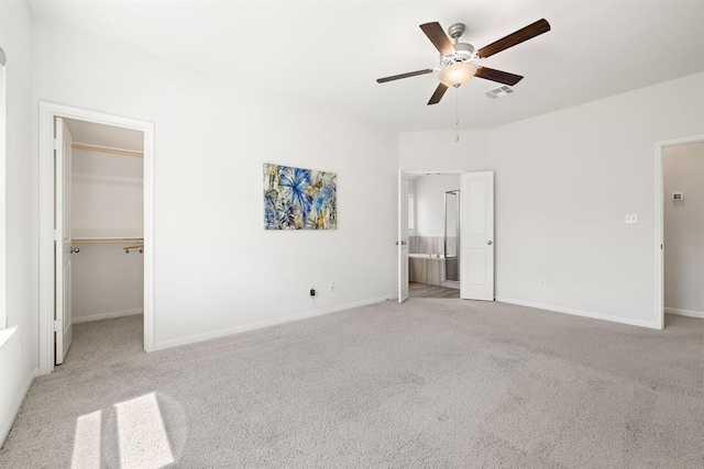 unfurnished bedroom with a spacious closet, baseboards, visible vents, and carpet floors