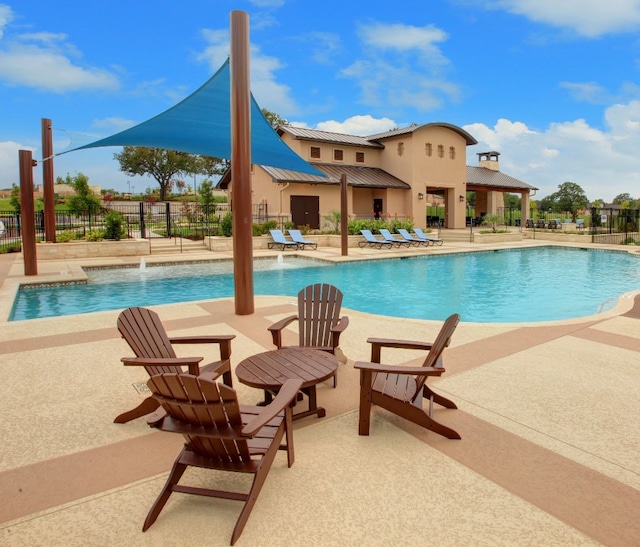 pool with a patio and fence