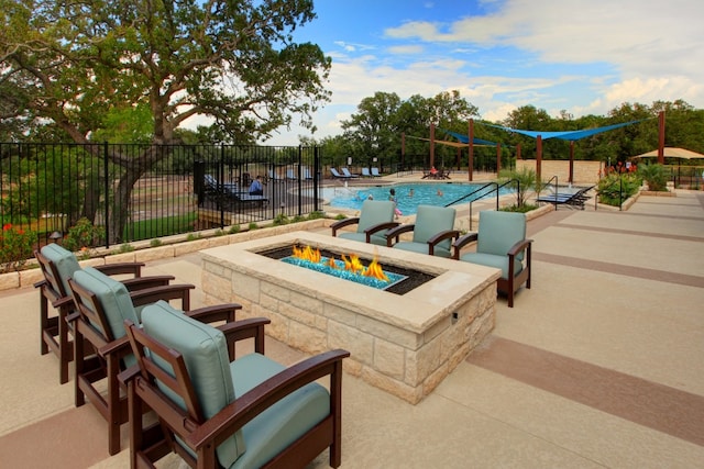 pool featuring a fire pit, a patio, and fence