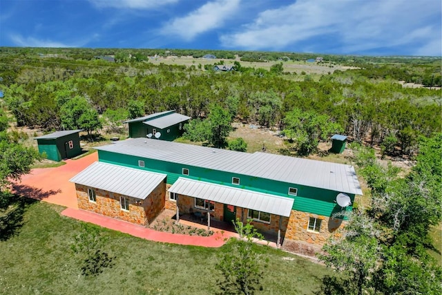 birds eye view of property featuring a wooded view