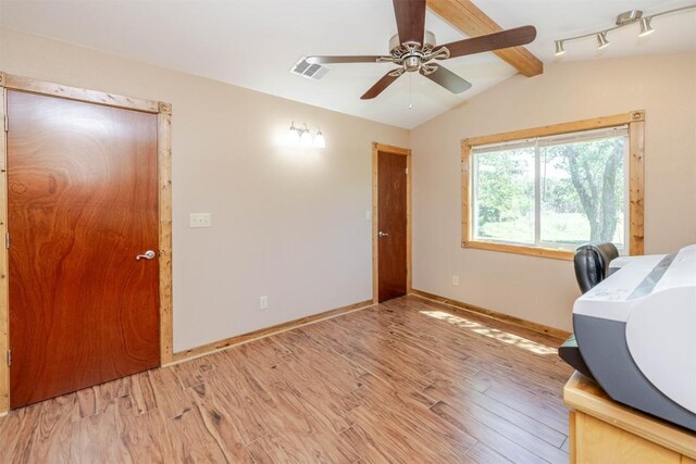 interior space with lofted ceiling with beams, baseboards, visible vents, and light wood-type flooring