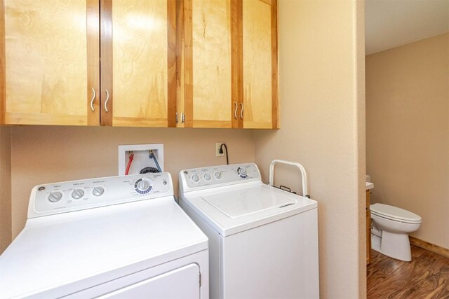 washroom featuring washing machine and dryer, wood finished floors, and laundry area