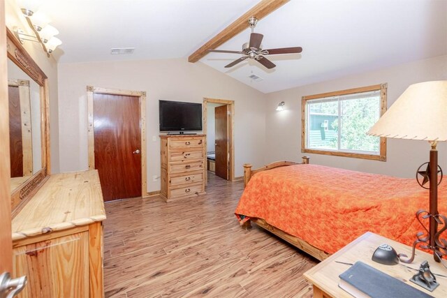 bedroom featuring lofted ceiling with beams, a ceiling fan, wood finished floors, and visible vents