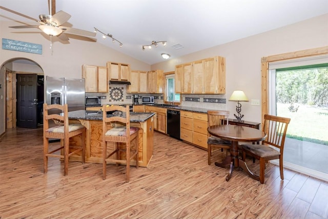 kitchen featuring light wood finished floors, light brown cabinets, lofted ceiling, and appliances with stainless steel finishes