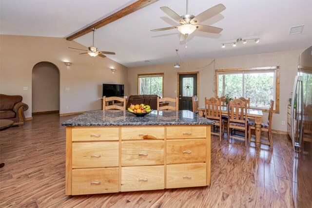 kitchen with ceiling fan, arched walkways, open floor plan, and light wood-style flooring