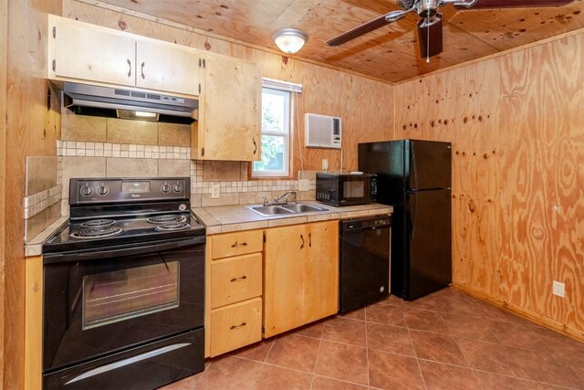 kitchen with a sink, ceiling fan, under cabinet range hood, tile countertops, and black appliances