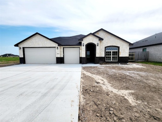 701 Eagle Claw Dr, Salado, TX 76571 - view of front of home with stone siding, concrete driveway, fence, brick siding, and an attached garage