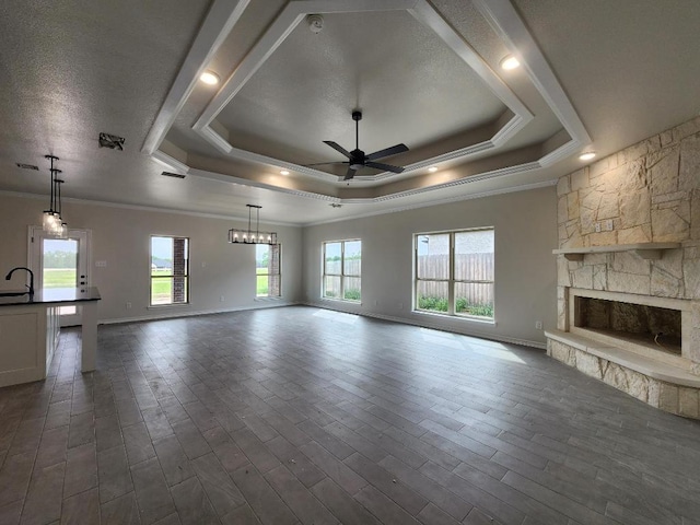 701 Eagle Claw Dr, Salado, TX 76571 - unfurnished living room featuring a tray ceiling, ornamental molding, and ceiling fan with notable chandelier